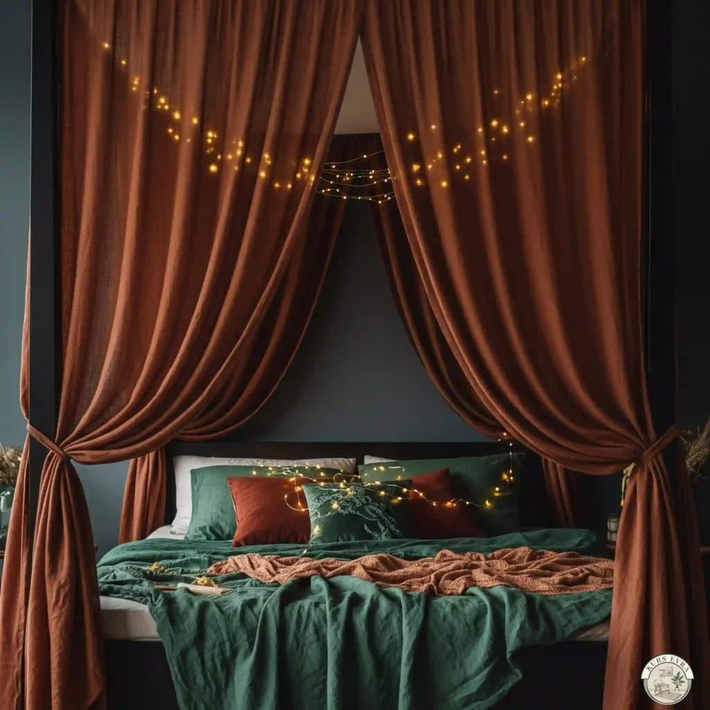  A dreamy canopy bed with sheer rust-colored linen drapes and fairy lights, styled with emerald green bedding against a charcoal wall.